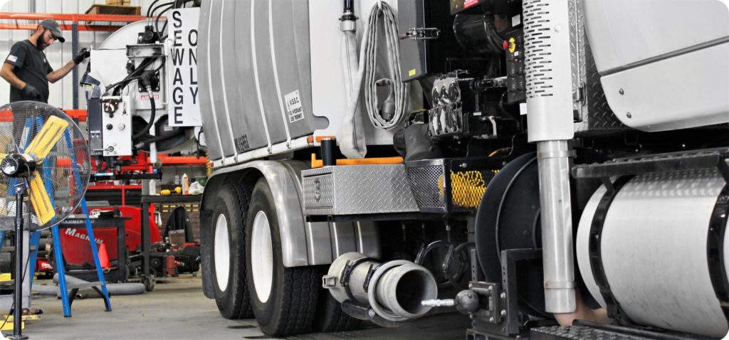 Technician repairs sewer vacuum truck