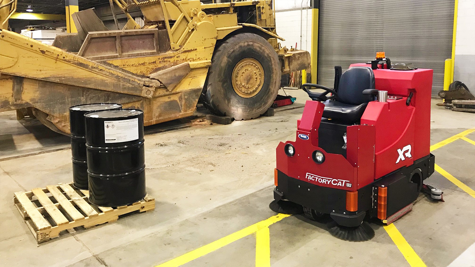 Ride-on floor scrubber cleaning an industrial floor