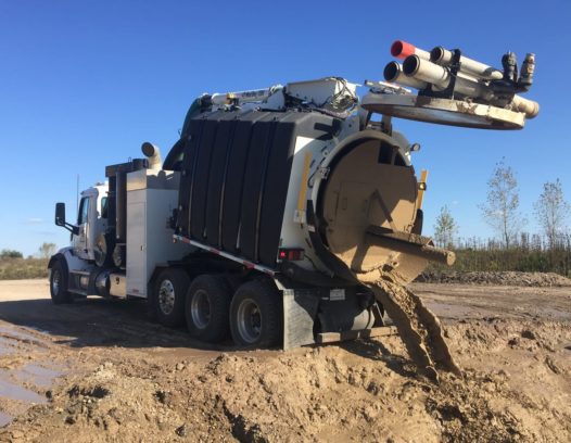 Mud Dog 1200 Vacuum Excavator dumping mud with its ejector plate