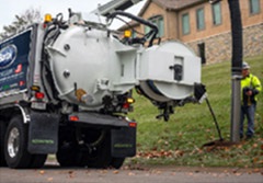 Man using a jet/vac truck to clean in an open manhole